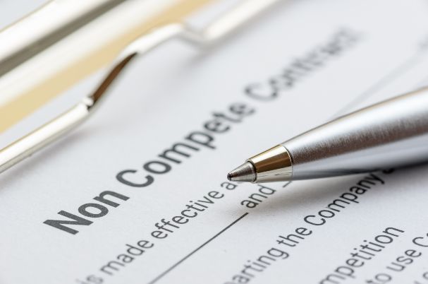 Court blocks non-compete ban photo concept of a non-compete contract with a pen resting on top.